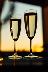 glass of champagne with splashing bubbles in the setting sun