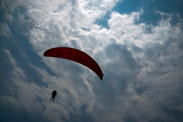 Paragliding flying in the blue sky.