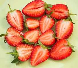 juicy halves of strawberries on a light green background. Healthy breakfast. Sweet life, mouth-watering strawberries, healthy nutrition. Red berry on a light background.