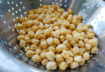 chickpeas, close-up, in a metal bowl, lit with light. The benefits or harms of chickpeas. Product high in carbohydrates, proteins and fatty acids. Diet, nutrition