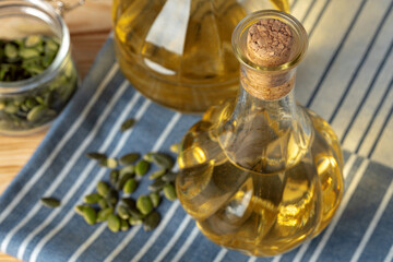 Fototapeta na wymiar Olive oil bottle on wooden table, close up.