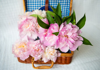 The beauty of a pink peonies bouquet in a vintage authentic brown suitcase.