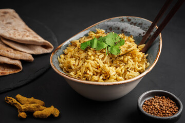 Khichdi decorated with parsley leaves near the condiments and bread made from whole wheat flour