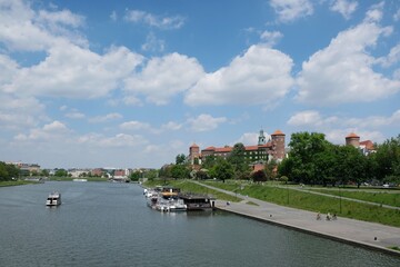 Wawel Royal Castle in Krakow, Poland. Exterior view from the Vistula River. Barges with restaurants standing by the river bank.