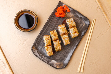 Roll in Bonito flakes tuna on a plate for sushi near the soy sauce and ginger and chopsticks view from above