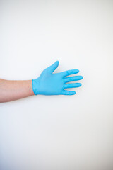 Hand in a blue medical disposable glove.