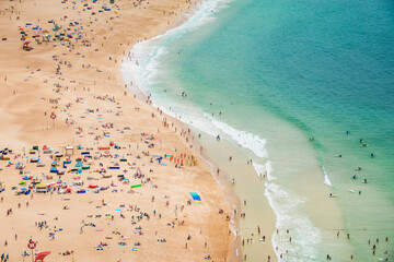 Panoramic aerial view of ocean beach with umbrellas. Beautiful long ocean beach with umbrellas and people drone view.