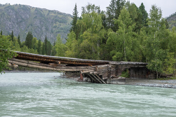 Fototapeta na wymiar Old wooden bridge made of logs. Altay, Kazakhstan.