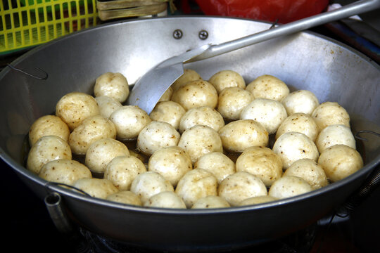 Fish balls being deep fried in a pan