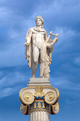 Fototapeta na wymiar Apollo statue with golden decorations against blue sky