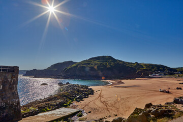 Image of La Greve de Lecq in the mornig sumer sunshine at low tide with sandy beach and clear blue sky. Jersey, Channel Islands, Uk
