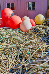 Image of old fishing ropes with float bouys in front of a timber fishing hut. Selective Focus, Jersey, Channel Islands, UK