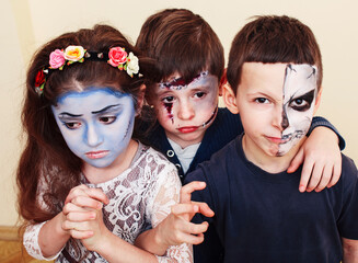 Obraz premium zombie apocalypse kids concept. Birthday party celebration facepaint on children dead bride, scar face, zombie skeleton together closeup makeup emotional posing.