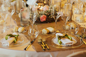 Beautiful festive table decoration in a restaurant. Beautiful cutlery on the festive table. Flowers and candles in a glass vase decorated in a restaurant. The romantic atmosphere.  