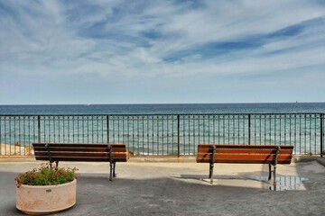 Fototapeta na wymiar Empty benches facing the sea