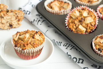 Healthy  apple oat muffins in the baking mold, one served on a plate