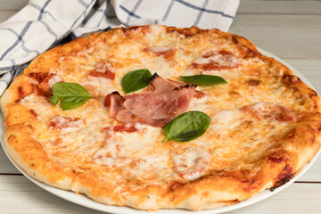 Homemade whole wheat pizza with tomato sauce, basil and grated cheese on top