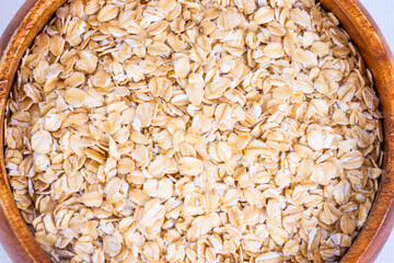 Raw oat flakes texture, healthy porridge background, copy space.