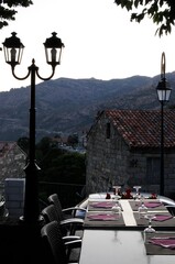 petite terrasse de restaurant pittoresque au sommet d'un village de montagne aux maisons en briques et lampadaires anciens