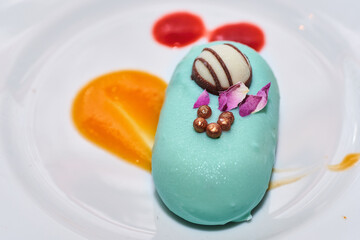 Individual portion of no bake cake sweet dessert. Delicious and beautiful trendy treat for special occasions. Romantic pastry dish. Blue chocolate smooth coating and round shape nicely decorated.
