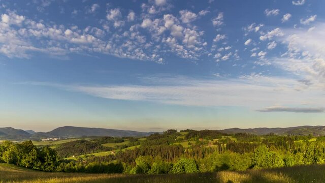 Timelapse wide view of clouds moving in the white sky overlooking the mountains and hills of the Beskydy Mountains shadows gradually crawling and changing the shadows on the ground.