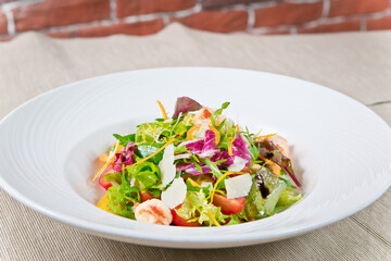 Delicious Caesar salad with prawns and Parmesan cheese. on a white plate. close-up view