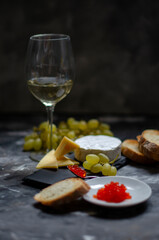 Camembert cheese with red caviar and white wine grapes