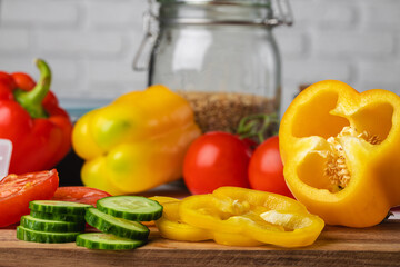 Cut vegetables on wooden board. Bell pepper, tomatoes and cucumbers