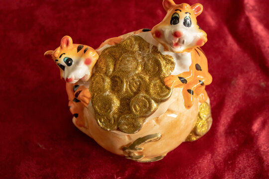 Children's toy made of porcelain material in the form of a tiger cub with gold and euro.