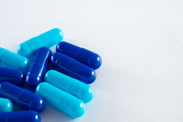 Blue capsules of medicine in white background.