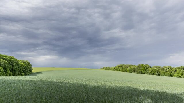 Timelapse view of a hilly field with freshly sown crops and dark clouds during storms and rains moving fast to the side of the Hranice na Morave Czech Republic