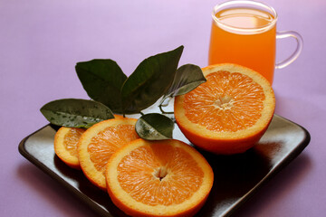 Healthy food concept: orange juice and fresh oranges on the plate, selective focus