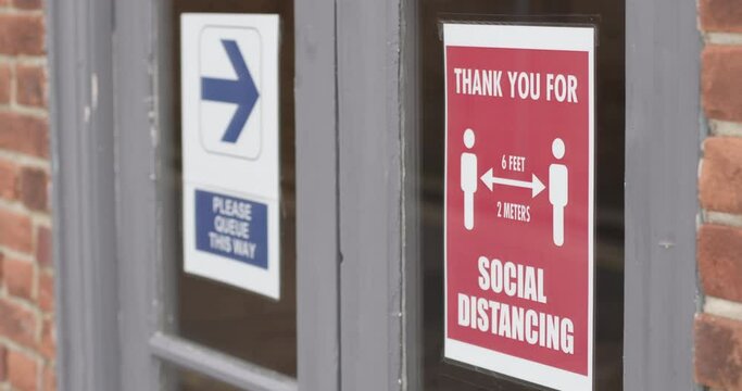COVID-19 Signage about social distancing on restaurant window during Corona pandemic, Life after lockdown new normal