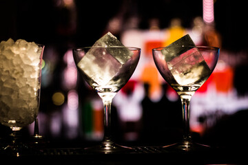 two glasses with ice cubes in them 