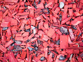small pieces of mahogany on the ground . red wooden background