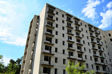 Photo background of an abandoned high-rise building under a blue sky. © Andrii Semenets
