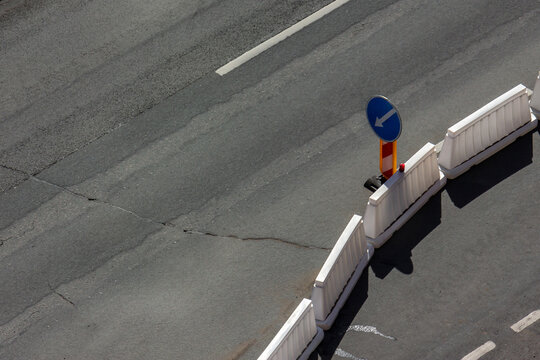 Traffic sign detour obstacles near the place of work on the repair of city streets. Modern plastic railings for the safety of the vehicle. Construction site top view