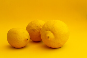 Fresh fruits concept: Lemons on yellow background, selective focus, free copy space