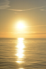 The sun sets  over the ocean in a golden haze a beautiful landscape taken from a cruise ship.
