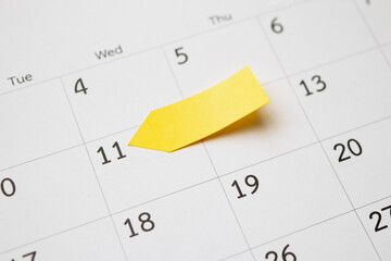 Blank yellow sticky adhesive post note paper planner with space on calendar page background for...