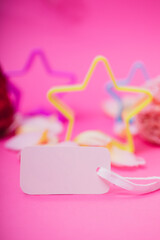White empty card and stars on pink background. Greeting card festive holiday pastel backdrop. Birthday congratulations.