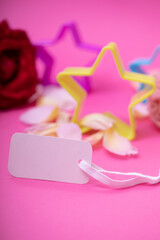 White empty card and stars on pink background. Greeting card festive holiday pastel backdrop. Birthday congratulations.