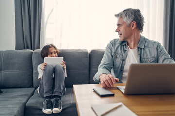 Happy man speaking to son in living room