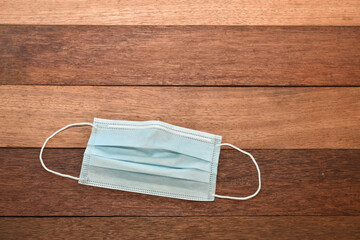 Face mask on wooden table texture background. 