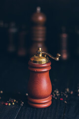 Pepper or coffee vintage wooden grinder on a dark black background