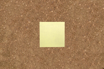Blank yellow sticky note postit on corkboard. Brainstorm, idea, to do.