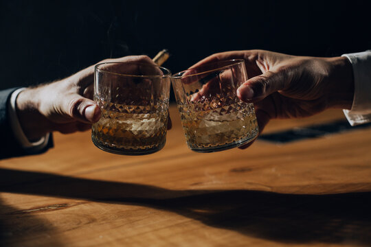 Close Up Of Two Men Toasting With Whiskey. 