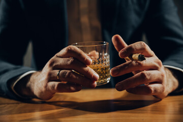 Close up of hands of man drinking whisky.	
