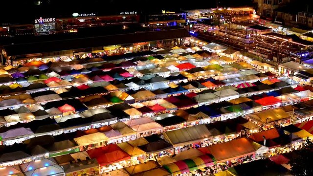 Ratchada Rot Foi Train night market in Bangkok, Thailand with rows of colourful tents stalls seen at night