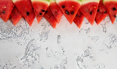 Pieces of ripe watermelon on a light texture background. Background idea, concept, top view.